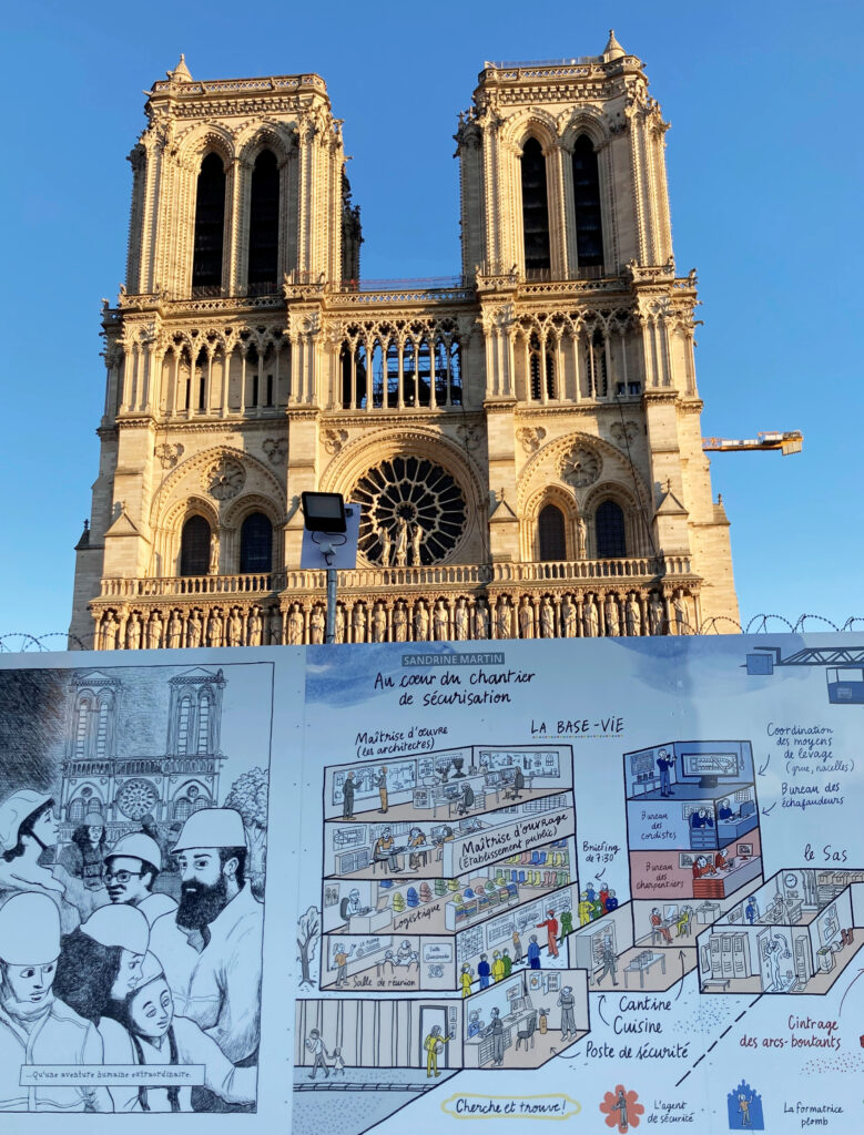 Notre-Dame Westfassade im Februar 2022: Comiczeichnungen auf dem Bauzaun legen dar, wo und wie die Arbeit auf der Kathedralen-Baustelle hinter der Absperrung stattfindet. (Foto Christiane Schillig)